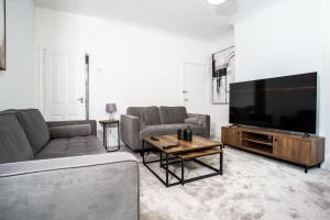 a living room with a couch and a large television at Modern 4BR Home in Dudley in Netherton