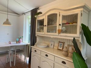 a kitchen with a white cabinet and a table at Bungalow 007 in Petten