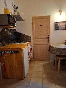 a kitchen with a stove and a door with a table at Gîte dans La circulade - Le Pouget in Le Pouget
