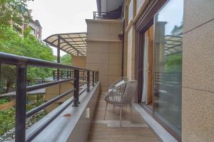 a balcony with two chairs sitting on it at Heinemann Hotel Terrace Double Room A206 with Jacuzzi and local amenities in Baoguosi
