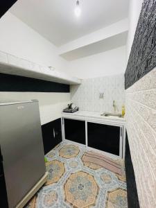 a kitchen with a refrigerator and a tile floor at Luxury apartment in Laayoune in Oulad el Haj