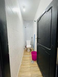 a bathroom with a toilet and a black door at Luxury apartment in Laayoune in Oulad el Haj