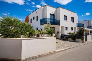 a white house with glass windows on a street at Villa Essenza Rossa in Vodice only 650 meters from the beach in Vodice
