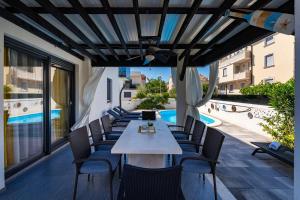 a patio with a table and chairs and a pool at Villa Essenza Rossa in Vodice only 650 meters from the beach in Vodice