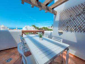 a blue table on a balcony with a view of the ocean at Suite adeje paradise with private jacuzzi in Adeje