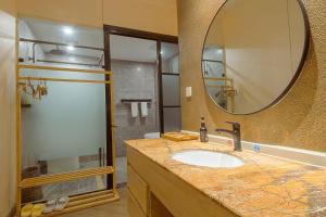 a bathroom with a sink and a mirror and a shower at Heinemann Hotel Terrace Double Room B206 with Jacuzzi and local amenities in Baoguosi