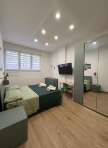 a bedroom with a bed and a desk and a television at CIAO PARTENOPE - luxury rooms in Naples
