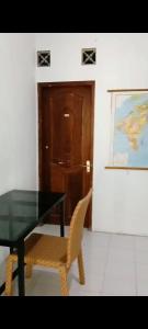 una mesa y una silla con una mesa y una puerta en Kasutapan homestay, en Kembangarum