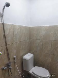 un baño con inodoro y ducha en Kasutapan homestay, en Kembangarum 1 foto más