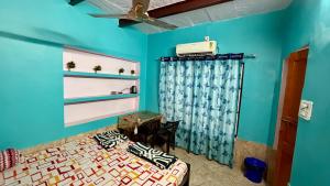 a bedroom with a bed and a blue wall at Tandon Lodge On The Ganga Ghat Homestay in Varanasi