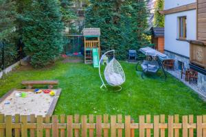 un patio trasero con arenero y juego en Villa Jarosta Premium, en Zakopane