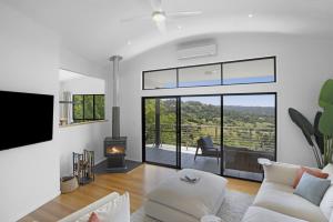 Una sala de estar con un sofá blanco y una chimenea. en Dale View Retreat at Mapleton, en Flaxton