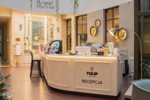 a restaurant with a counter in a store at Tulip Hotels - Wroclaw Patio in Wrocław