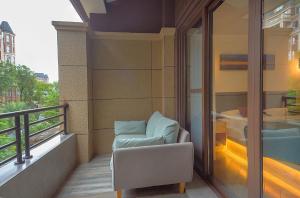 a balcony with a chair and a window at Heinemann Hotel loft suite with two king beds B306 with a jacuzzi and a local in Baoguosi
