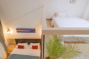 a bedroom with two beds and a palm tree in it at Heinemann Hotel loft suite with two king beds B306 with a jacuzzi and a local in Baoguosi
