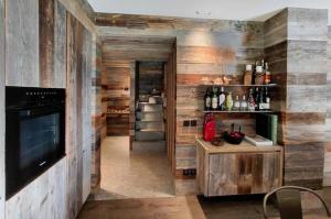 a living room with wooden walls and a television and a staircase at TERRY LODGE-Luxury Apartment-central ski area in Aprica