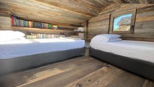 two beds in a room with wooden walls at TERRY LODGE-Luxury Apartment-central ski area in Aprica
