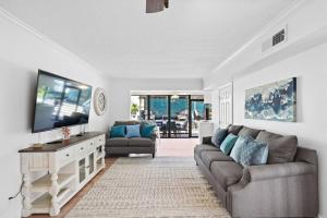 Una sala de estar con un sofá y un televisor de pantalla plana. en Cozy home close to Kemah Boardwalk with game room, en Clear Lake Shores