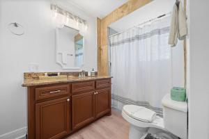 Un baño con inodoro, lavabo y espejo. en Cozy home close to Kemah Boardwalk with game room, en Clear Lake Shores 53 fotos más