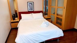 Un dormitorio con una cama grande con sábanas blancas. en Harmony Living Condominium, en Makkasan 185 fotos más