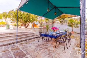 a blue table and chairs under a blue umbrella at Villa Maravillas by Slow Villas in Playa de Palma +32 photos