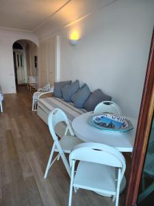 a living room with a couch and a table and chairs at Casa vista Faraglioni Capri 2 in Capri +8 photos
