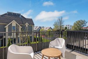 a balcony with two chairs and a table at Stay in the Heart of the City 3 Bed 3 Bath in Christchurch