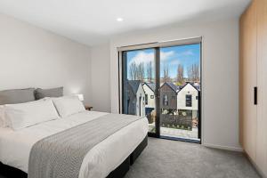 a bedroom with a bed and a large window at Stay in the Heart of the City 3 Bed 3 Bath in Christchurch