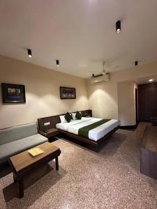 a bedroom with a large bed and a couch at Hotel Mount Regency by SAH in Mount Ābu