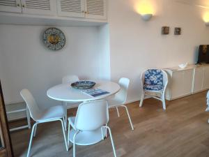 a dining room with a white table and chairs at Casa vista Faraglioni Capri in Capri