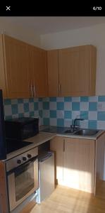 a kitchen with wooden cabinets and a sink and a stove at Lovely double bed private studio in tullamore town in Tullamore