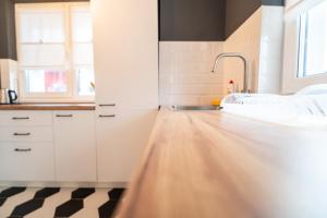 a kitchen with white cabinets and a wooden floor at BCB Aparts Wood Nest in Floreşti +46 photos