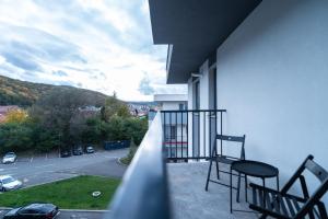 a balcony with two chairs and a view of a street at BCB Aparts Wood Nest in Floreşti
