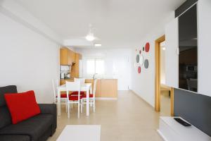 a living room with a couch and a table at Tu refugio en Canet, piscina, parking y playa in Canet de Berenguer