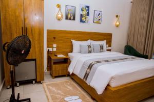 a bedroom with a large bed and a fan at Standard Double Room in Kigali