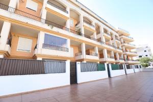 an apartment building with white fences and balconies at Tu refugio en Canet, piscina, parking y playa in Canet de Berenguer