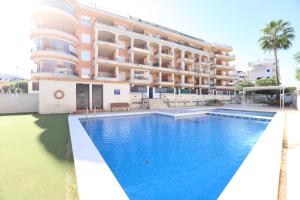 a hotel with a swimming pool in front of a building at Tu refugio en Canet, piscina, parking y playa in Canet de Berenguer