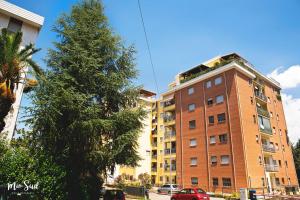 een hoog bakstenen gebouw naast een palmboom bij Mio Sud in Cosenza