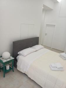 a bedroom with a large bed and a side table at Dimora Marte in Sammichele di Bari