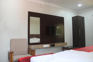 a bedroom with a mirror and a bed and a tv at SRG Shivam Residency in Tiruvannāmalai