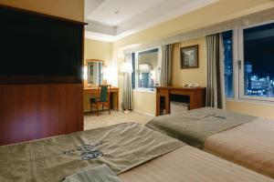 a hotel room with two beds and a flat screen tv at Boston Plaza Kusatsu Biwa Lake - Vacation STAY 15442v in Kusatsu