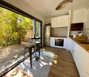 a kitchen with a table and a large window at La Villa de l'Horloge - Family in Montpellier! in Montpellier