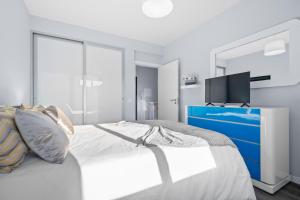 a bedroom with a bed with a blue dresser and a tv at Mimi Holiday House - Free Parking in Funchal