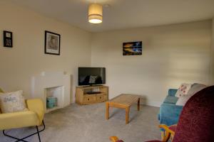 Una sala de estar con un sofá y un televisor. en Tigh-na-mara, Helmsdale, en Helmsdale