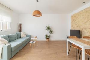 a living room with a blue couch and a table at Mirador de la Peña in Arcos de la Frontera