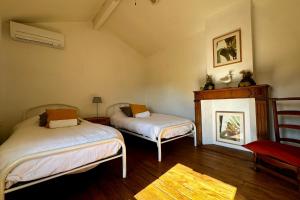 a bedroom with two beds and a fireplace at La Villa de l'Horloge - Family in Montpellier! in Montpellier