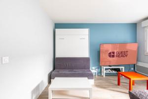 a living room with a couch and a tv at GuestReady - Cosy and sunny studio in Antony in Antony