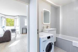 a white bathroom with a washing machine and a sink at GuestReady - Cosy and sunny studio in Antony in Antony