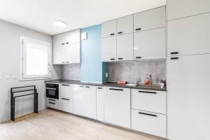 a kitchen with white cabinets and a sink at GuestReady - Cosy and sunny studio in Antony in Antony +4 photos