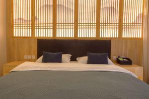 a bedroom with a large bed with at Heinemann Hotel standard king room Building A with a jacuzzi and a local in Baoguosi +2 photos